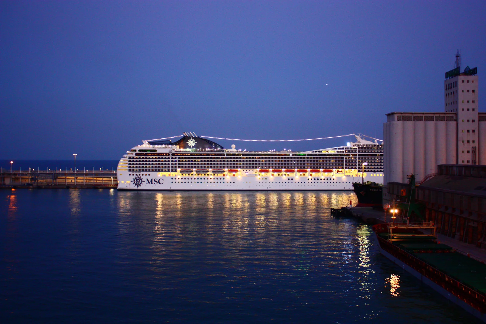 Un crucero iluminado en el puerto de Barcelona al anochecer