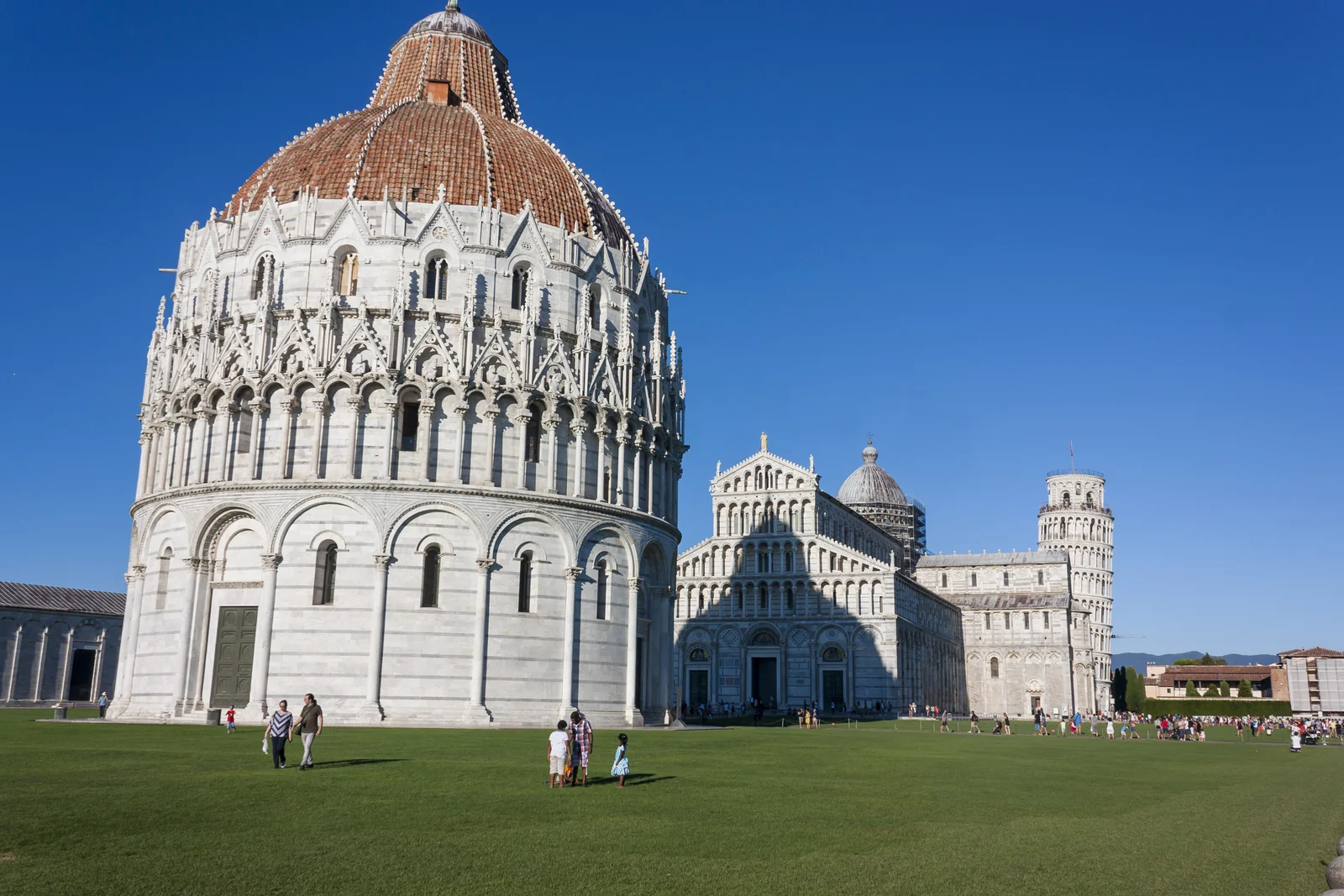 Baptisterio de Pisa, catedral y torre inclinada junto al césped