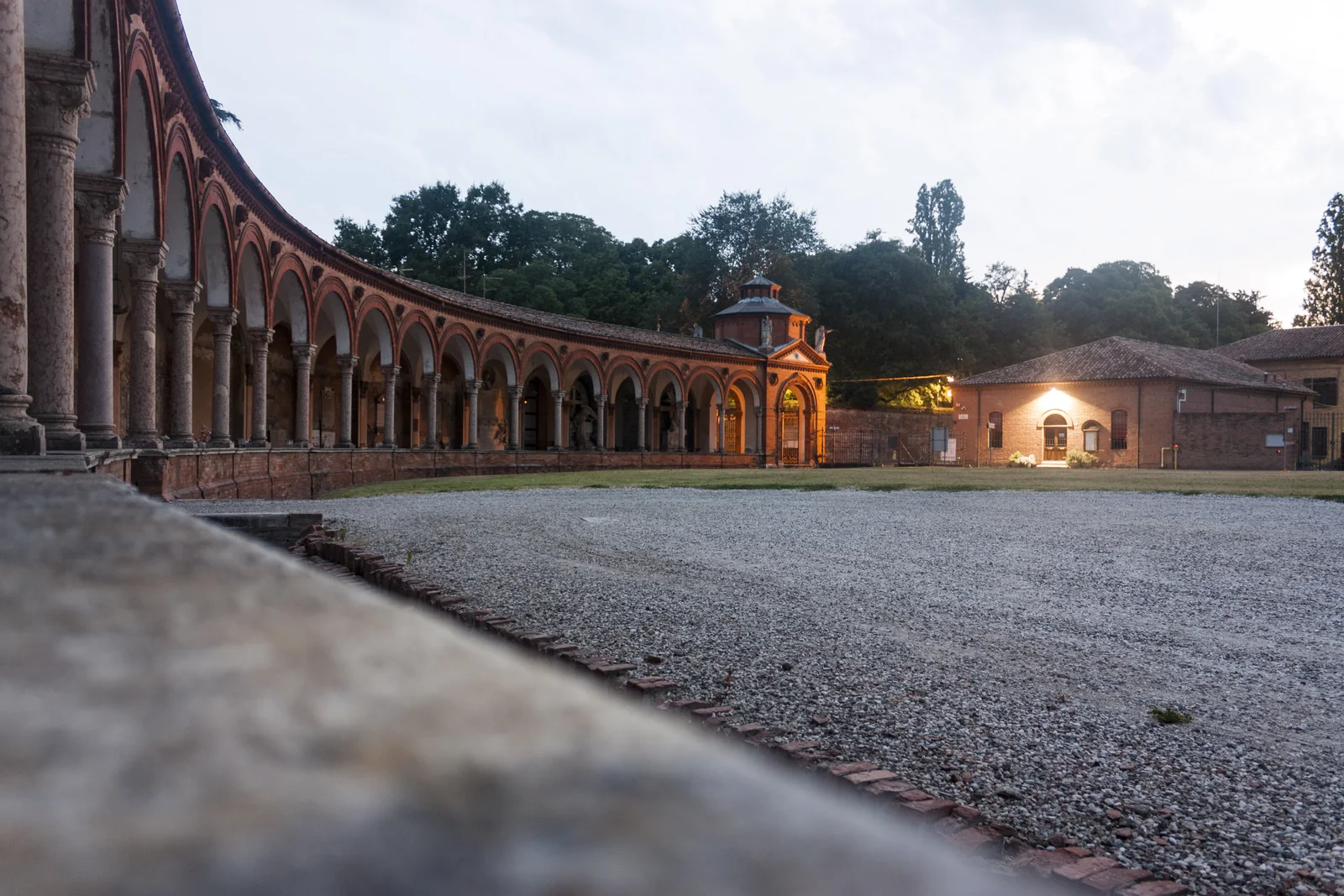 Arcadas de ladrillo y caminos de grava de Ferrara al atardecer
