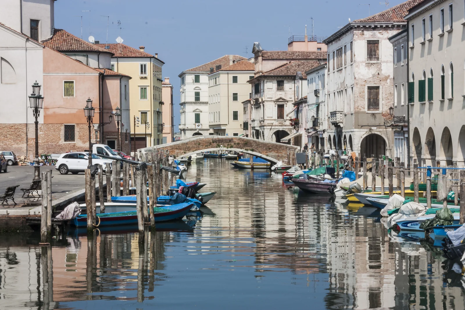 Barcas y fachadas de colores reflejadas en un canal de Chioggia