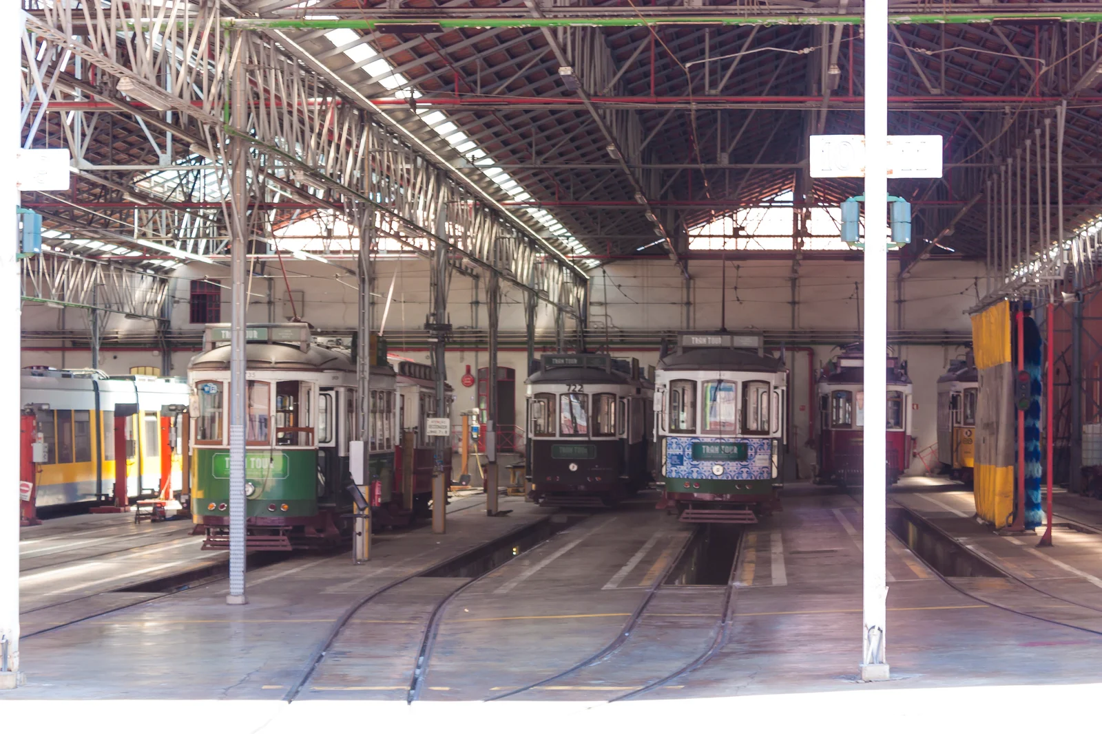 Interior de una nave con tranvías históricos en Lisboa.