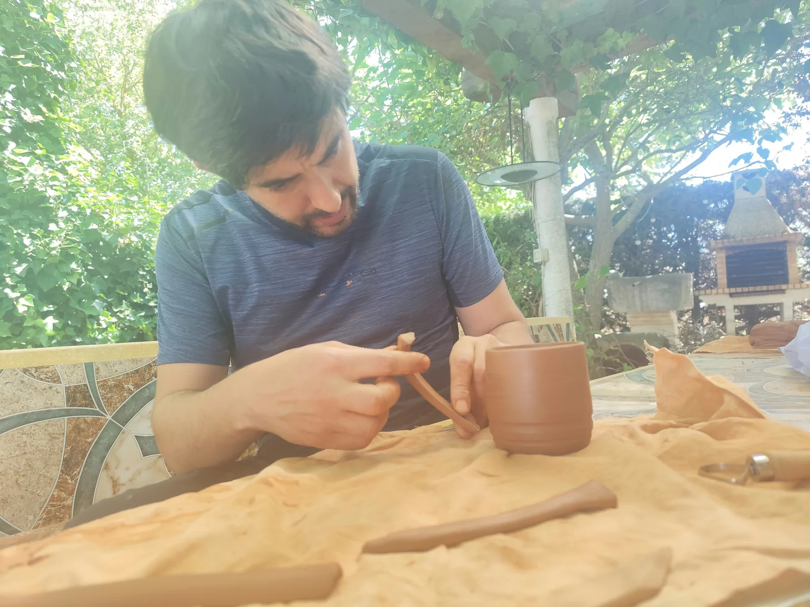 Víctor trabajando con herramientas manuales sobre una pieza de arcilla.